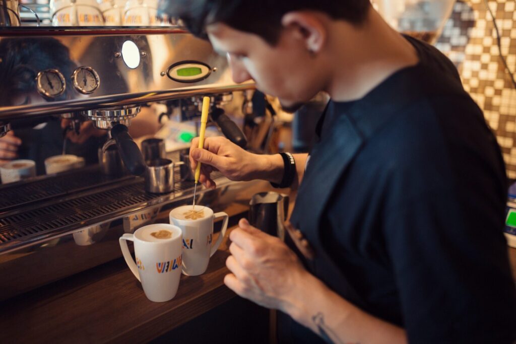 barista at work in a coffee shop e1651646891707